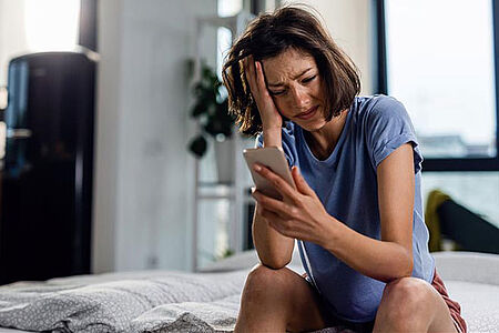 traurige Frau mit Handy 